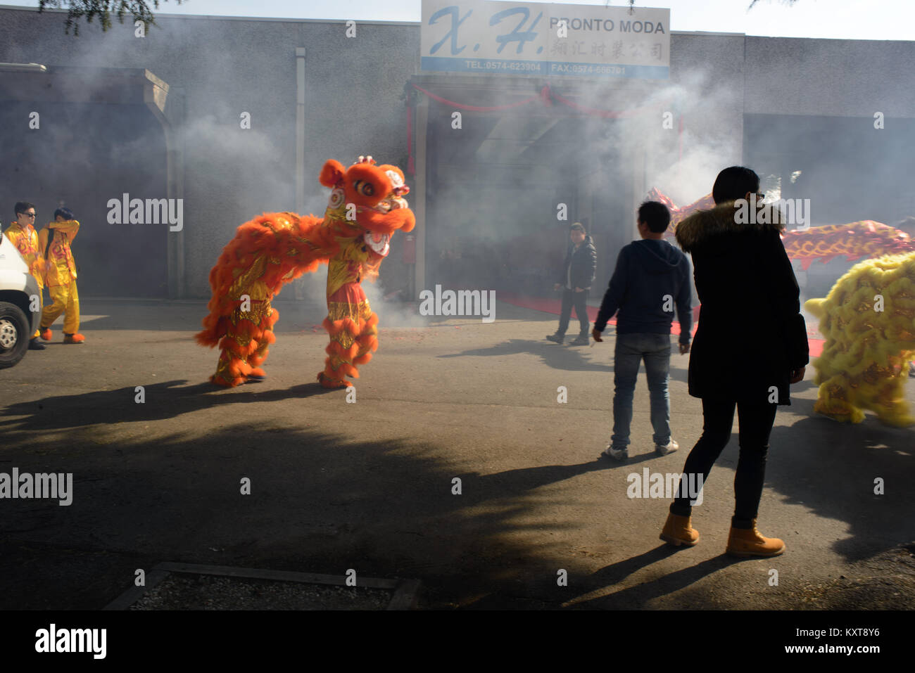 Célébrations du nouvel an chinois 2015 à Prato, Italie. Personnes et un dragon rouge dans la fumée des pétards. Banque D'Images