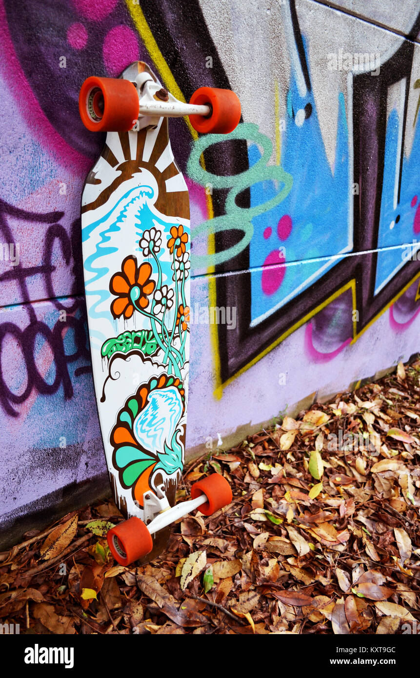 Longskate skateboard leaning against wall avec graffiti Banque D'Images