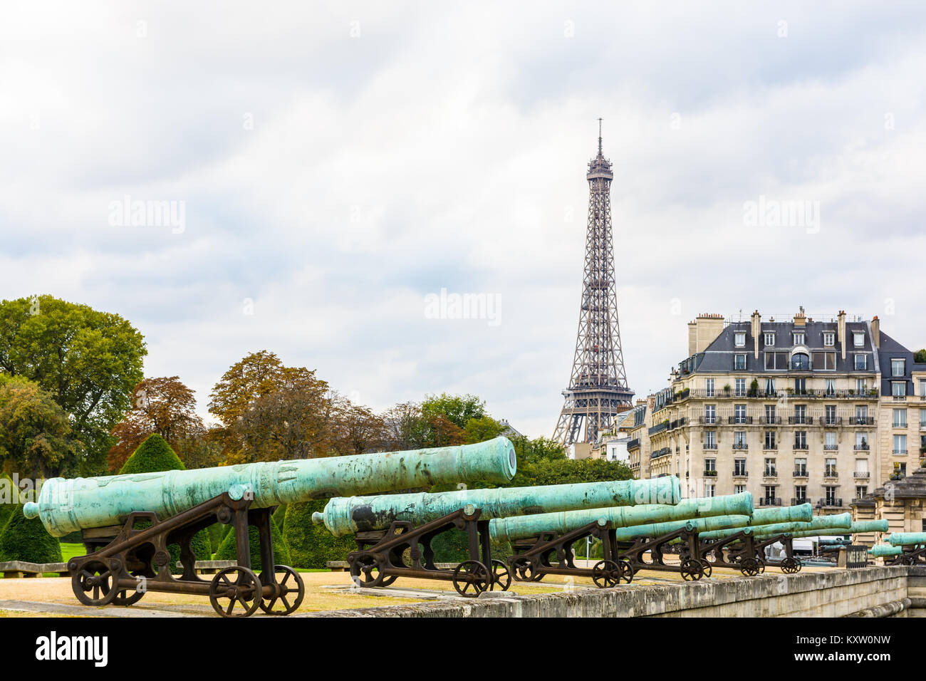 Vue sur la Tour Eiffel avec la rangée de canon en bronze de la Place des Invalides' dans l'avant-plan et d'un immeuble typiquement parisien dans le backgroun Banque D'Images