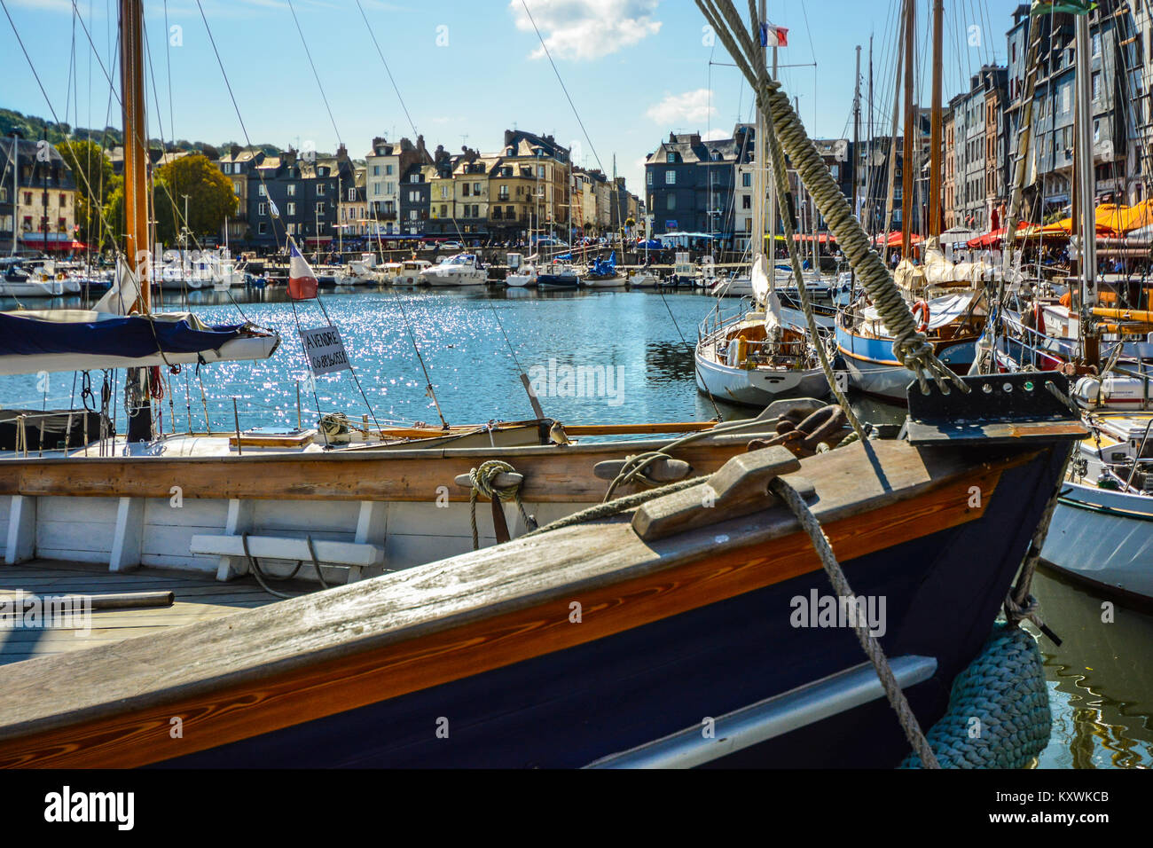 Un petit oiseau se trouve sur la proue d'un voilier sur une journée ensoleillée dans le port de Honfleur sur la côte normande en France Banque D'Images