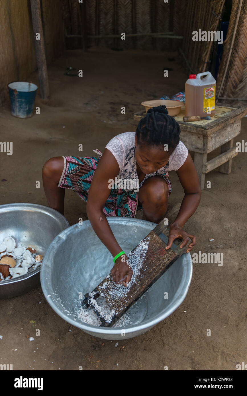Le broyage de la chair de noix de coco sur un self-made. Production de l'huile de noix de coco,Aziza Island dans le fleuve Volta, Ada Foah, Région Grand Accra, Ghana, Afri Banque D'Images