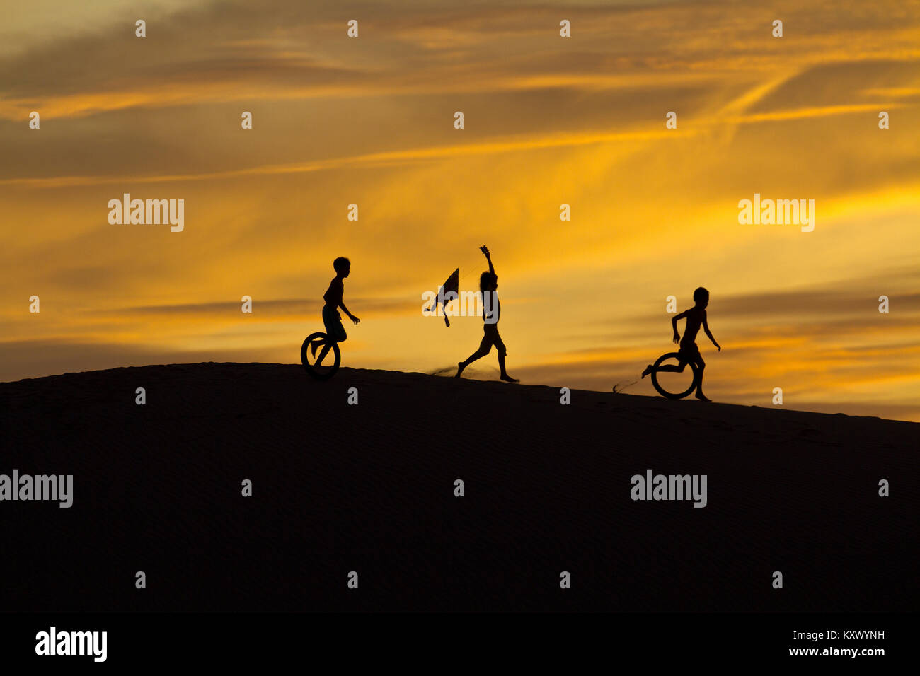 Tôt le matin au lever du soleil - Enfants jouant dans les dunes de sable près de Phan Rang, le centre du Vietnam Banque D'Images