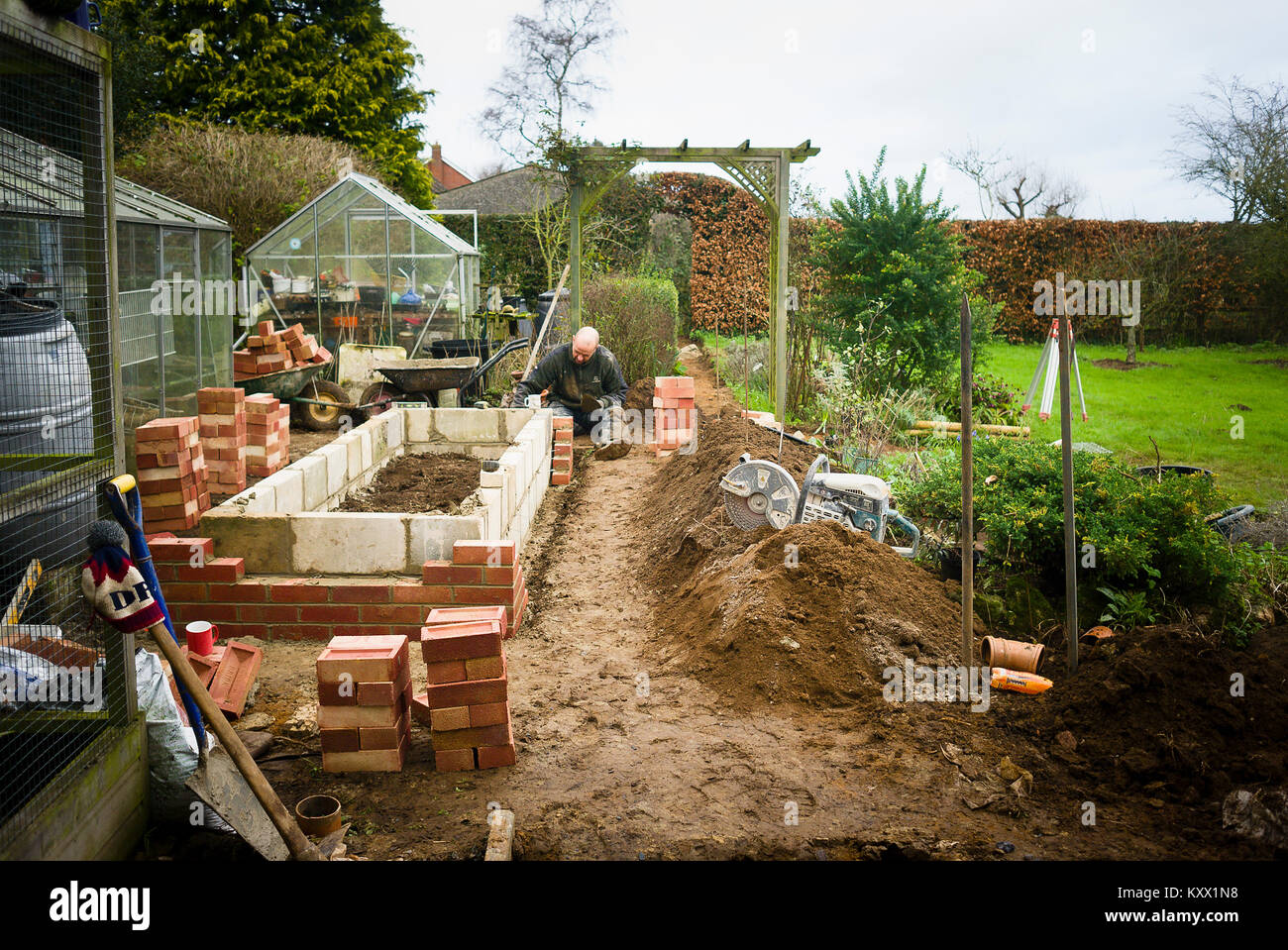 Builder construire un substitut du semoir relevé à partir de blocs et de briques à la fin de l'hiver en UK Banque D'Images