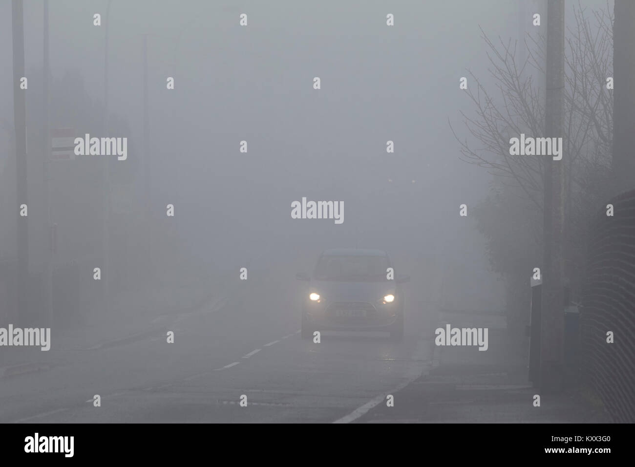 La conduite sur voiture sans clignotants 997 rue de banlieue à travers le brouillard en un jour brumeux au Royaume-Uni Banque D'Images