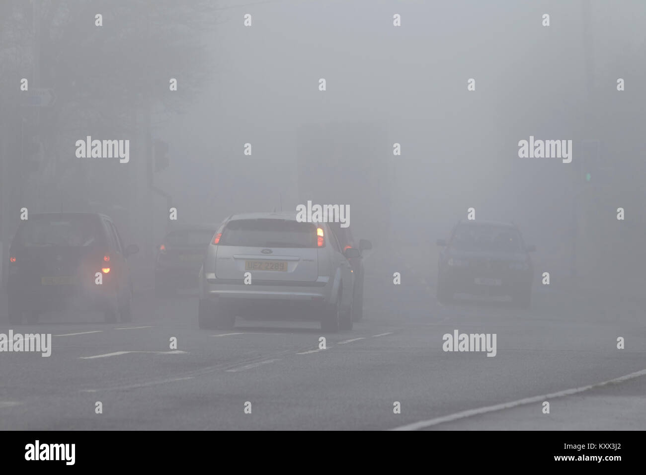Voitures à un carrefour certains sans lumières sur jour brumeux au Royaume-Uni Banque D'Images