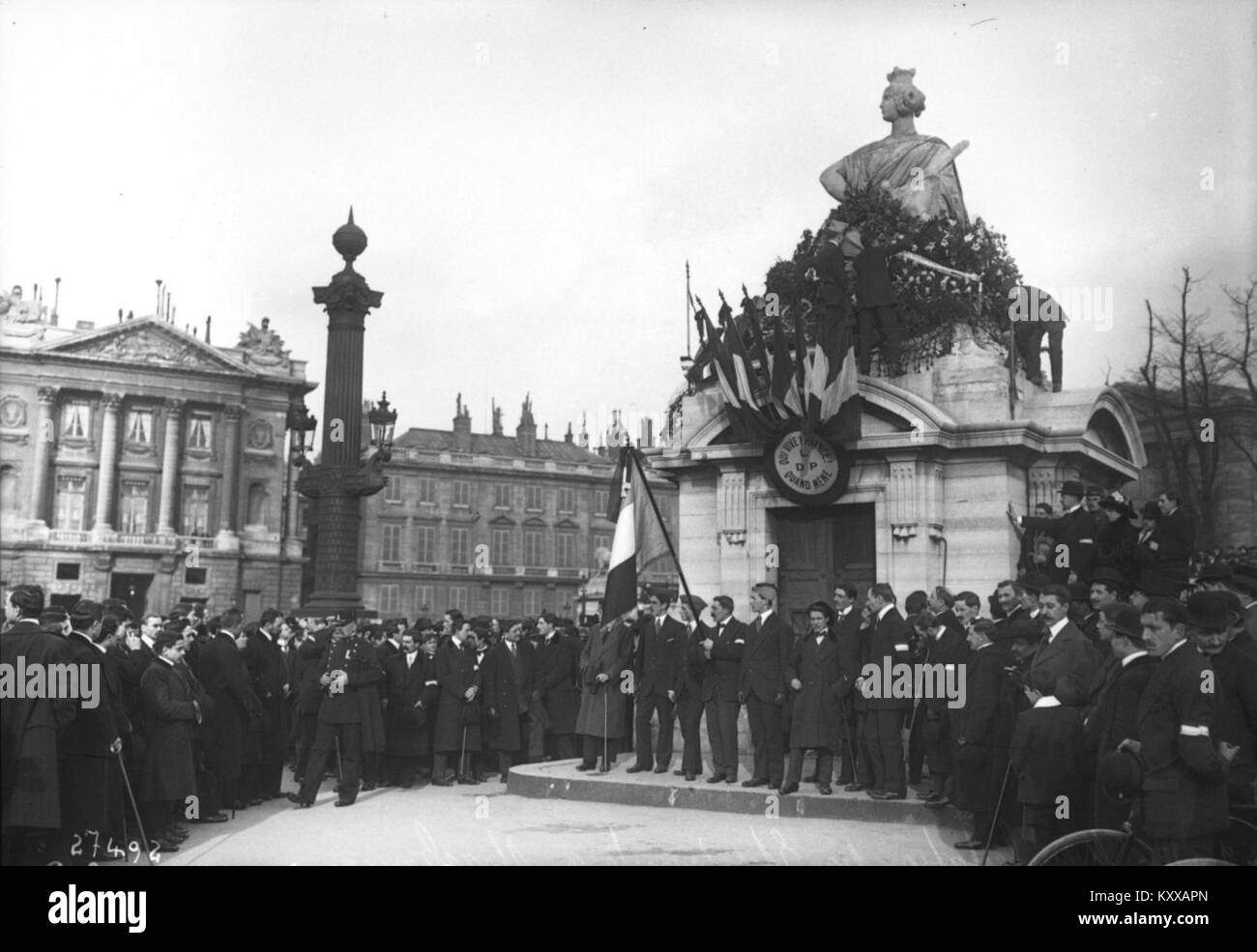 Une photographie de 1913 montrant des étudiants rassemblés autour de la statue de Strasbourg à Paris, commémorant la ville perdue par l'Allemagne après la guerre franco-prussienne. L’image capture l’expression patriotique et l’activité sociale chez les étudiants français. Banque D'Images