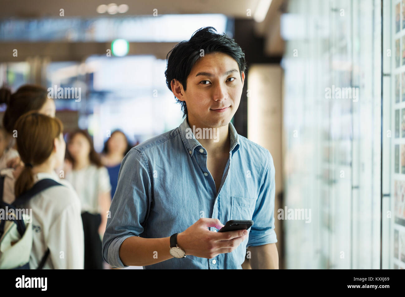 Businessman wearing blue shirt, holding mobile phone. Banque D'Images
