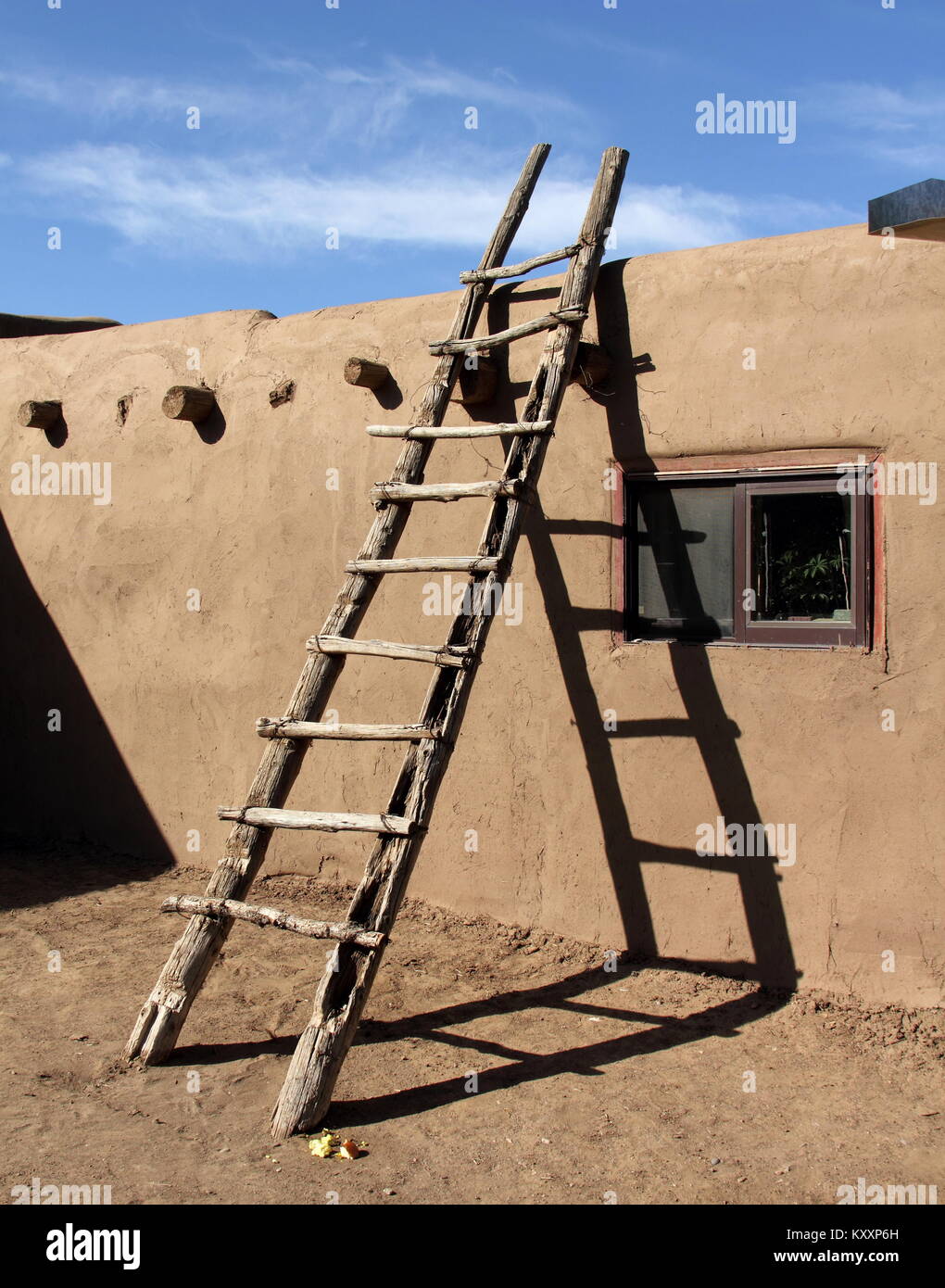Le sud-ouest de l'échelle appuyée contre le mur d'adobe à Taos Pueblo, New Mexico Banque D'Images