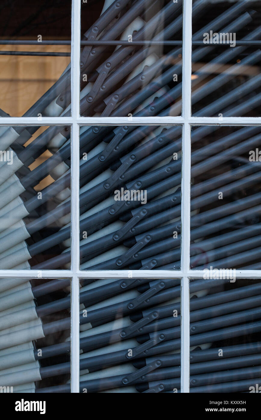 Gamme de chaises pliantes empilés dans une fenêtre du bâtiment Banque D'Images