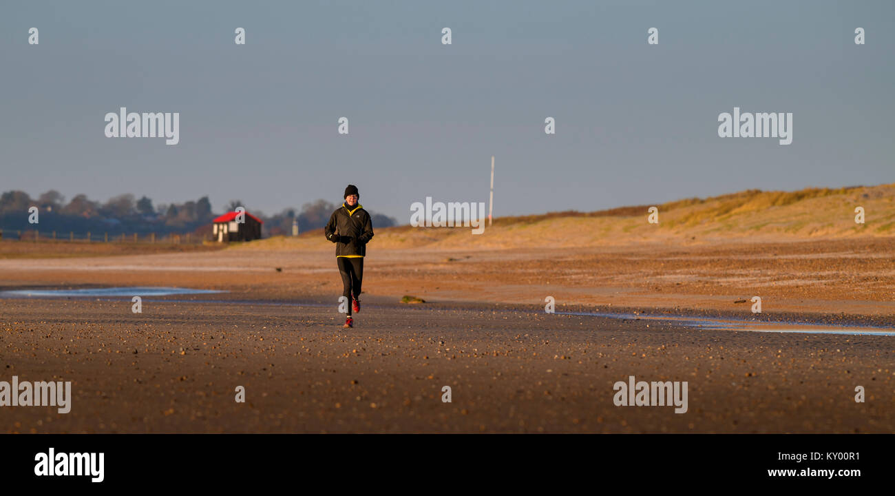 Runner sur plage de carrossage en hiver le soleil. Banque D'Images