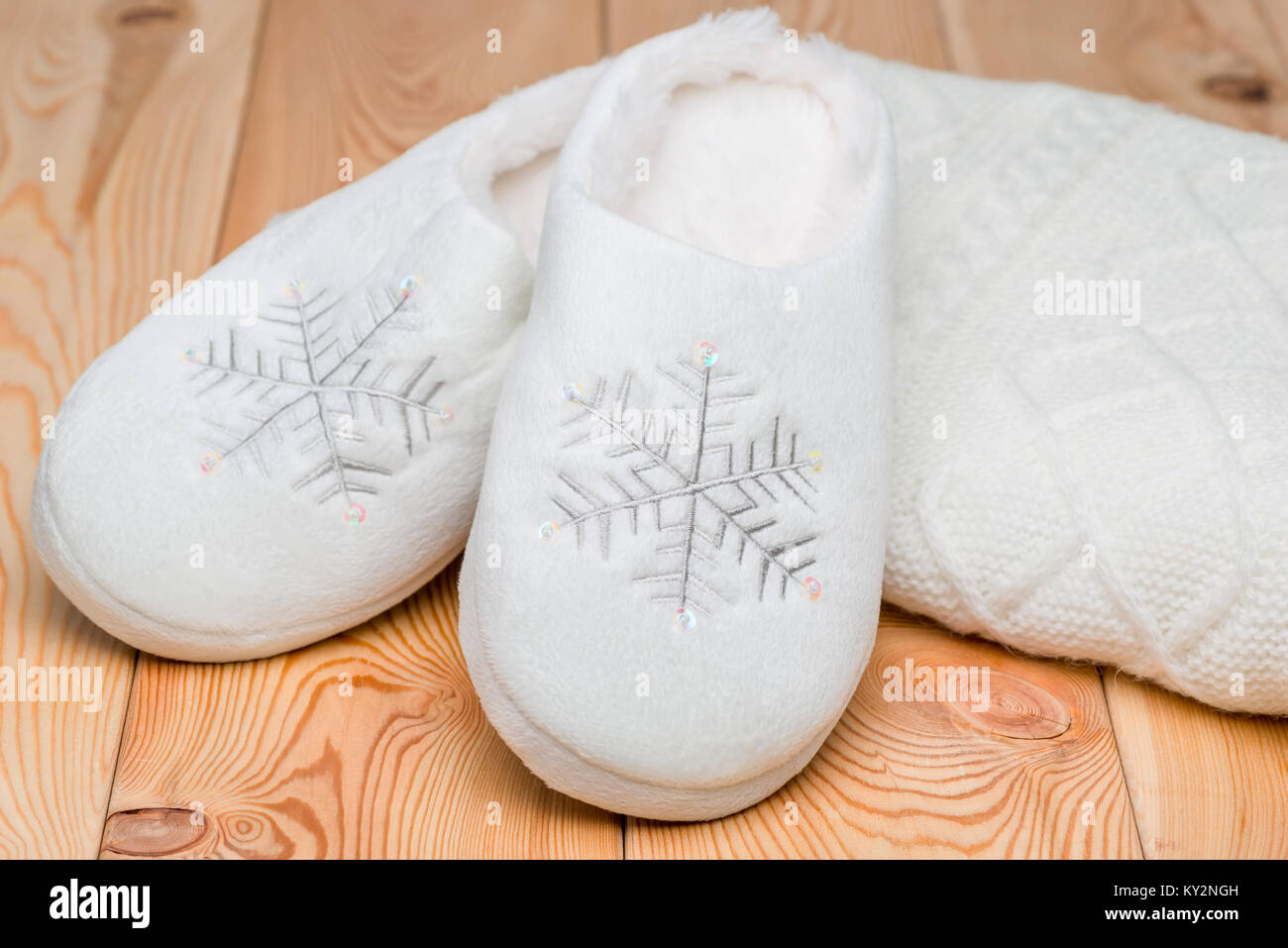 Chaud blanc chaussons et un chandail tricoté close-up, sur chaussons broderie flocons Banque D'Images