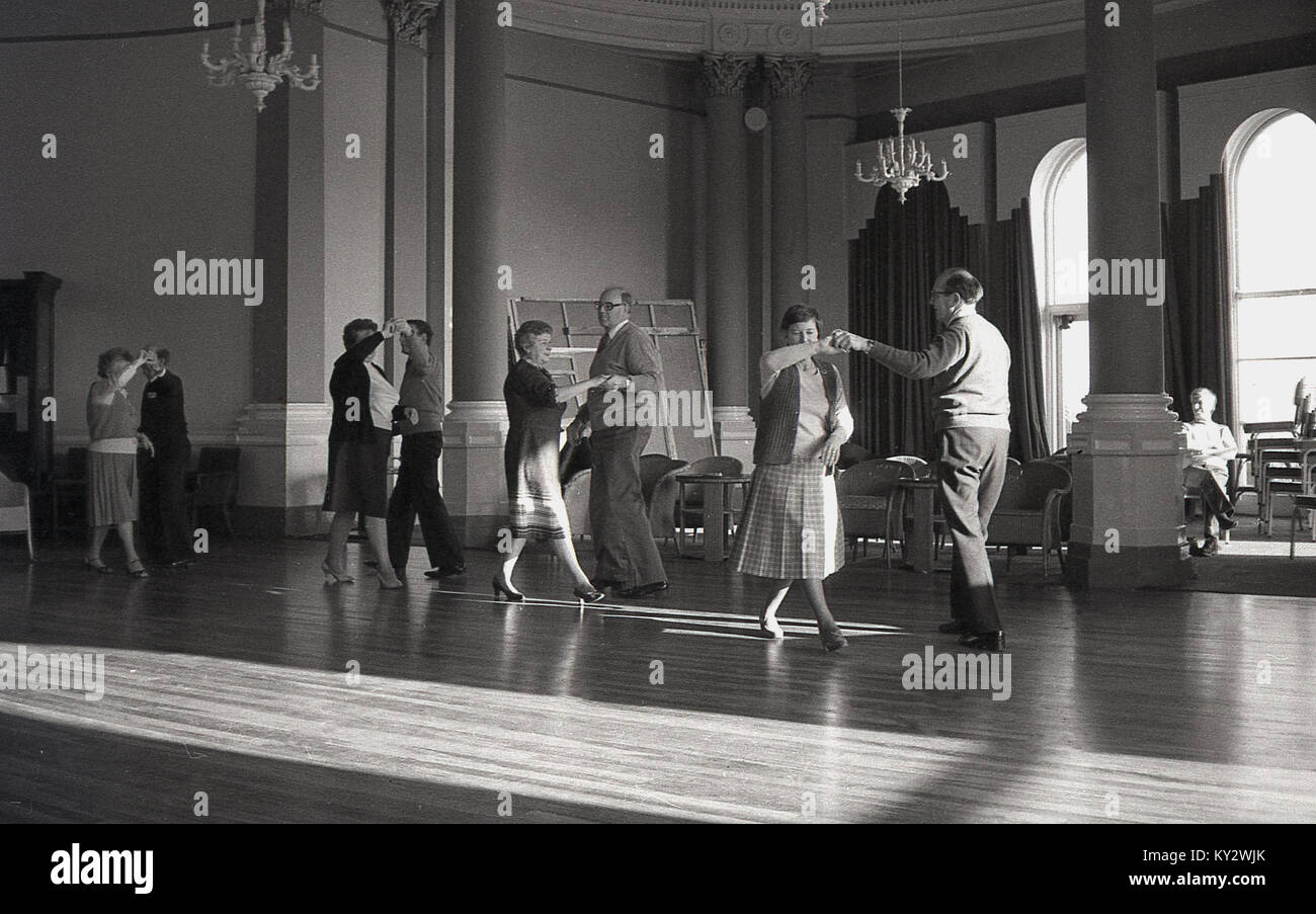 Des années 1970, l'Angleterre, les hommes plus âgés et les femmes bénéficiant de l'activité sociale d'un après-midi thé dansant dans une salle de bal d'un hôtel. Banque D'Images