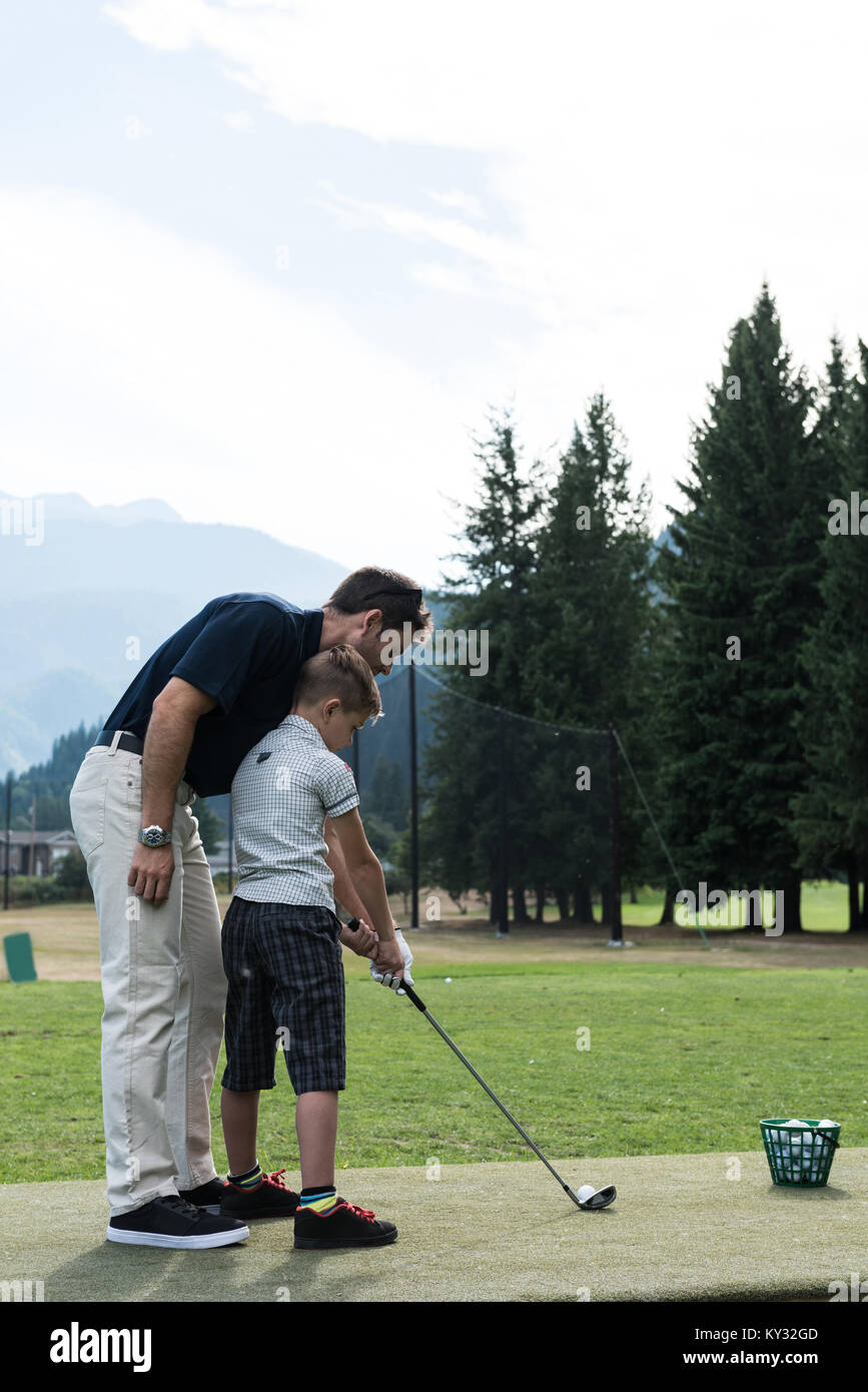 Père aide son fils à jouer au golf Banque D'Images