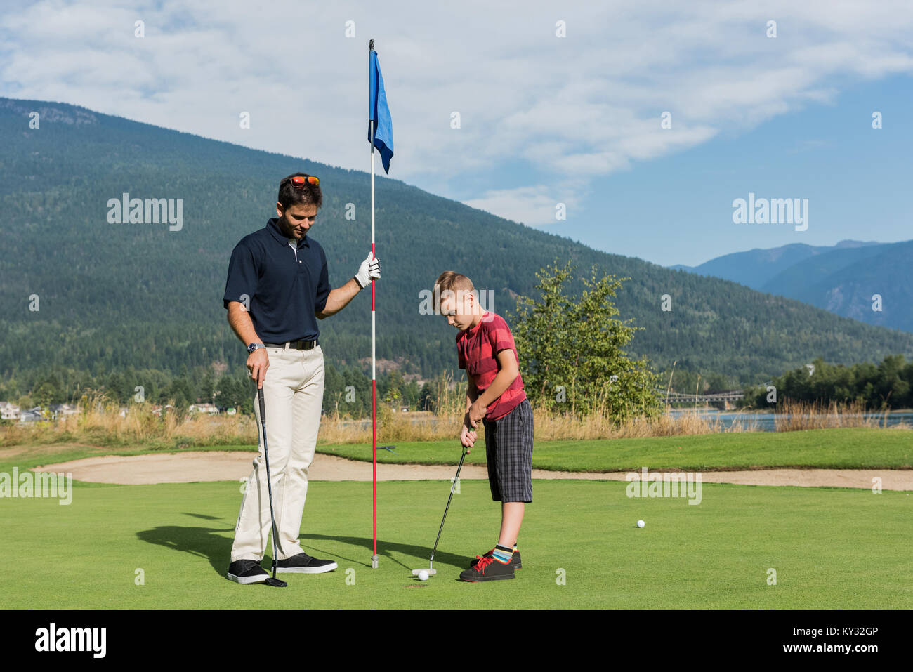 Père aide son fils à jouer au golf Banque D'Images