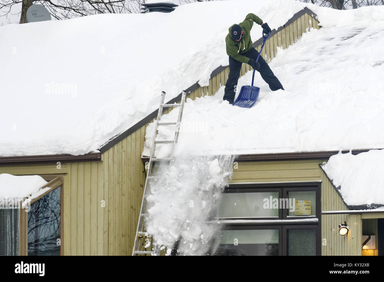 Un homme déblayer la neige du toit d'une maison, la ville de Québec en hiver Banque D'Images