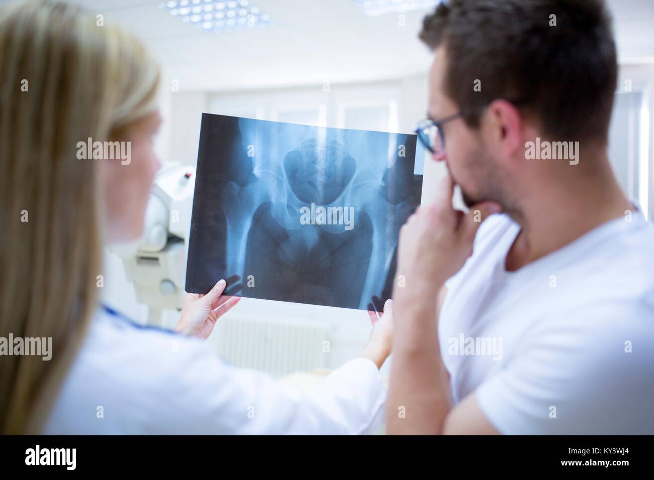 Deux médecins holding x-ray d'un bassin humain de sexe masculin. Banque D'Images