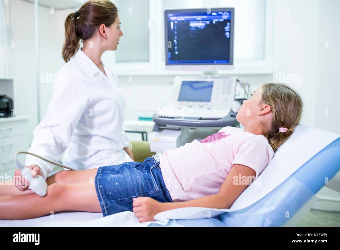 L'échographiste ultrasons sur la jambe de la jeune fille. Banque D'Images