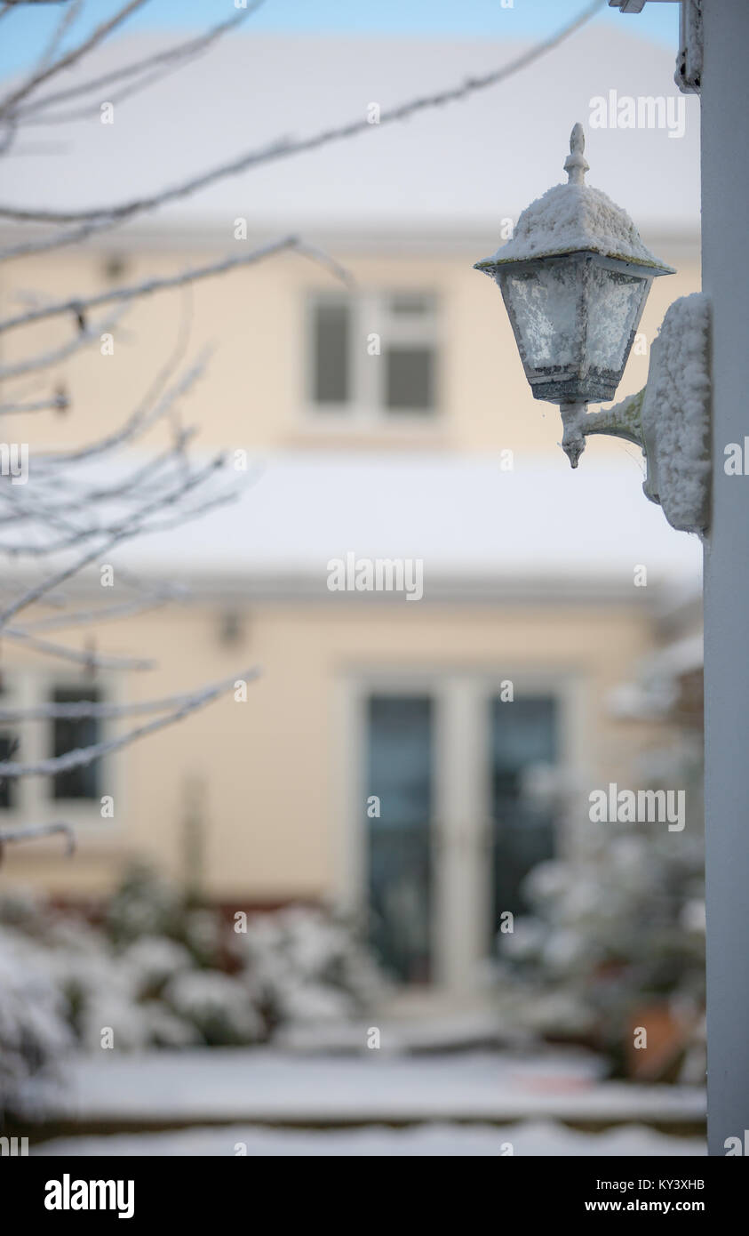 Un coup d'hiver lumineux de la capture d'un style traditionnel coach extérieur lanterne couverte de neige. Soft-focus contexte montre bien couverte de neige et jardin. Banque D'Images