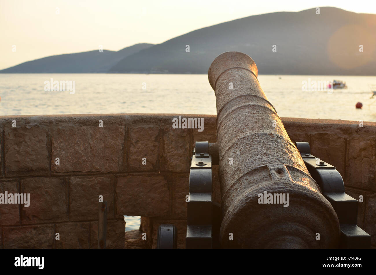 Old cannon adresse au coucher du soleil dans la mer Banque D'Images