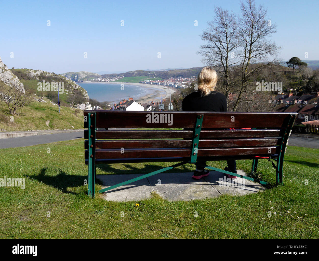 Tout en profitant de la vue dame assise sur un banc en regardant vers la baie de Llandudno en route vers le grand orme Country Park, Llandudno, au nord du Pays de Galles, Royaume-Uni Banque D'Images