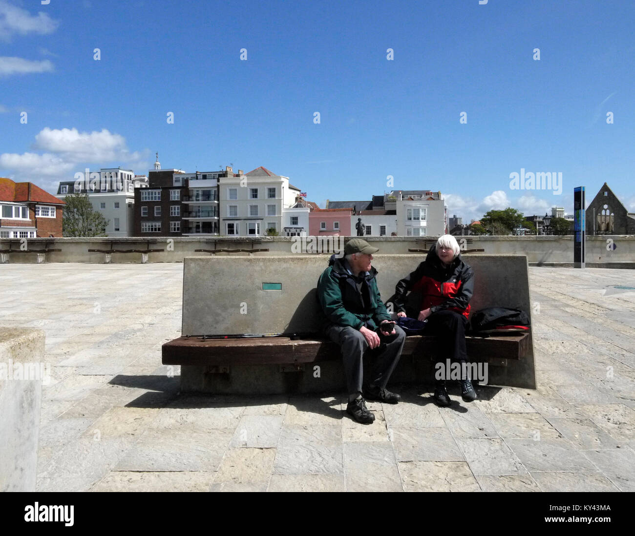 Couple assis sur banc commémoratif moderne sur le front de Portsmouth, Portsmouth, Hampshire, England, UK, Banque D'Images