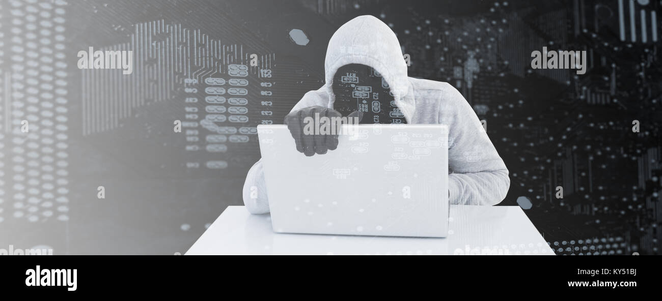 Image composite de randonneur en gris à capuche et gants using laptop Banque D'Images