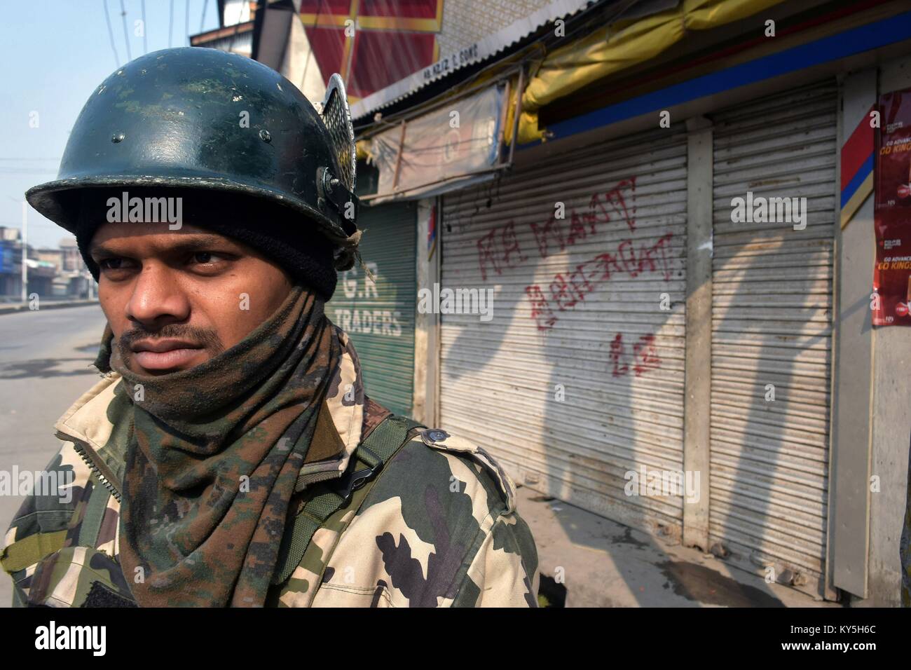 Srinagar, au Cachemire. 13 Jan, 2018. Un Kashmirn policier montent la garde devant les boutiques fermées pendant un couvre-feu dans la région de Srinagar, Cachemire administré par Kashmirn. Les autorités ont imposé des restrictions de Srinagar, en plus de parties de civil lines le samedi à la suite de grève déclenchée par les séparatistes à l'encontre de civils dans la vallée. Credit : Saqib Majeed/SOPA/ZUMA/Alamy Fil Live News Banque D'Images