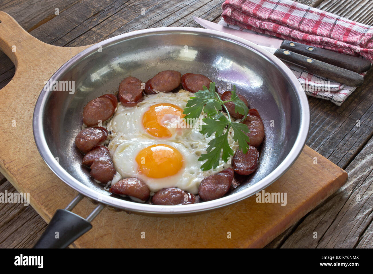 Les œufs et saucisses en plat de cuisson sur table en bois Banque D'Images