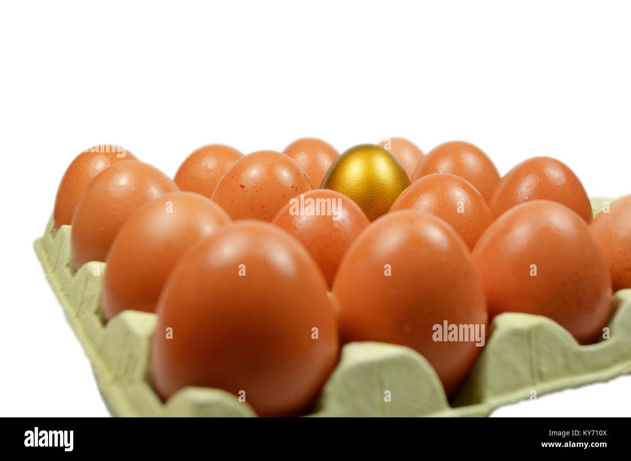 Oeuf d'or dans une boîte d'oeufs normaux avec isolé blanc Banque D'Images