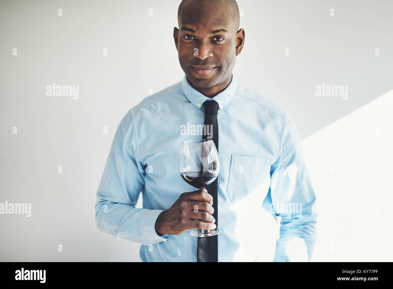 Mature sophistiquée homme africain dans une chemise et cravate de boire un  verre de vin rouge Photo Stock - Alamy