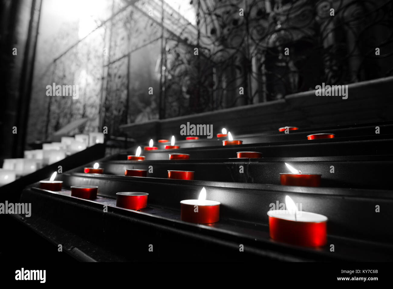 Bougies votives lumignons église rouge couleur noir et blanc sélectif Banque D'Images
