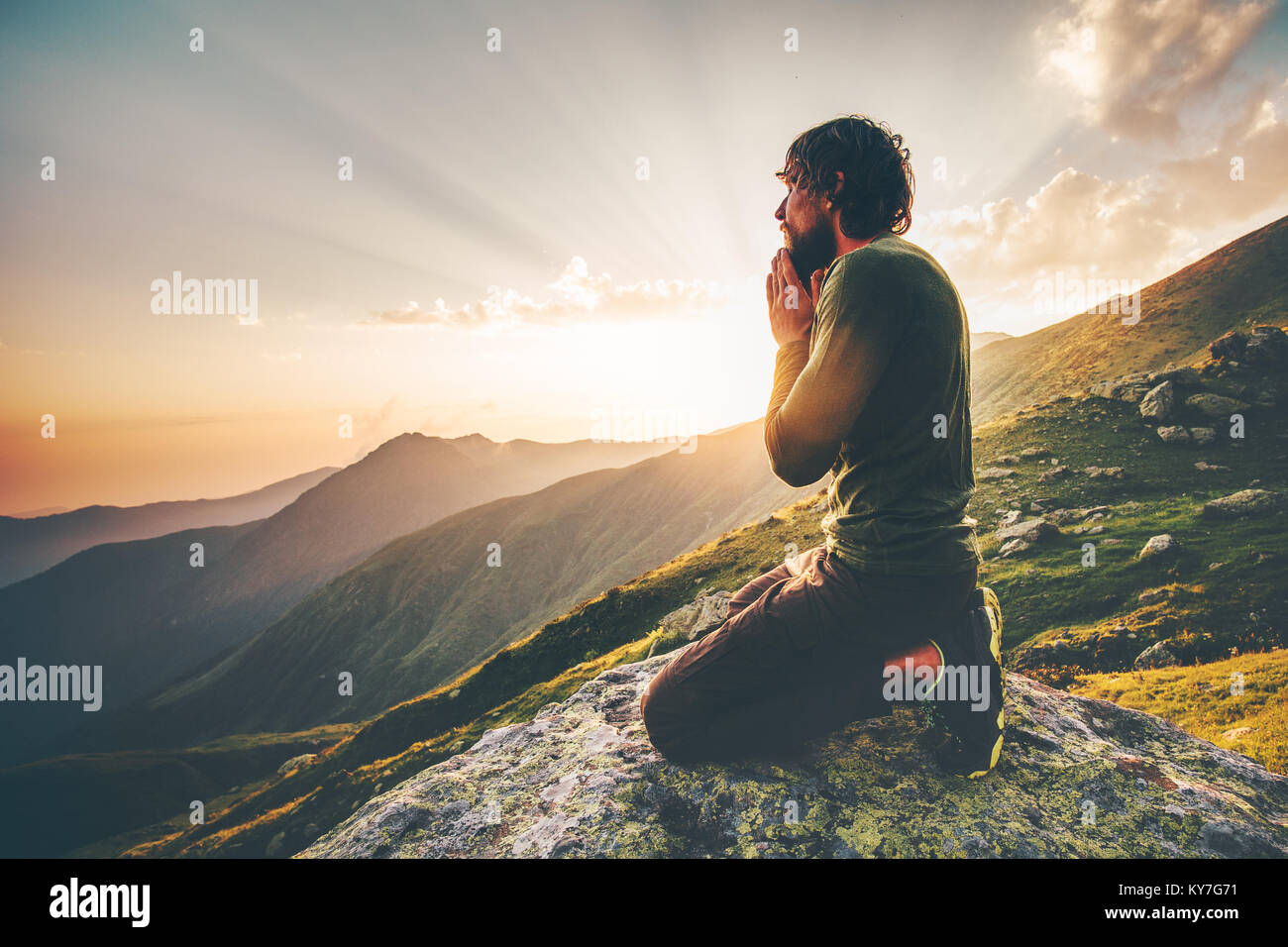 Homme qui prie au coucher du soleil spirituel de vie voyage montagne concept émotionnel de relaxation en plein air vacances harmonie avec nature paysage Banque D'Images