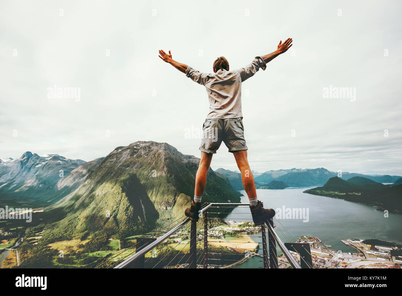 Les mains de l'homme soulevées au bord cliff Rampestreken monument en Norvège Voyage montagne concept active risque de vie heureux Vacances en tourisme Banque D'Images