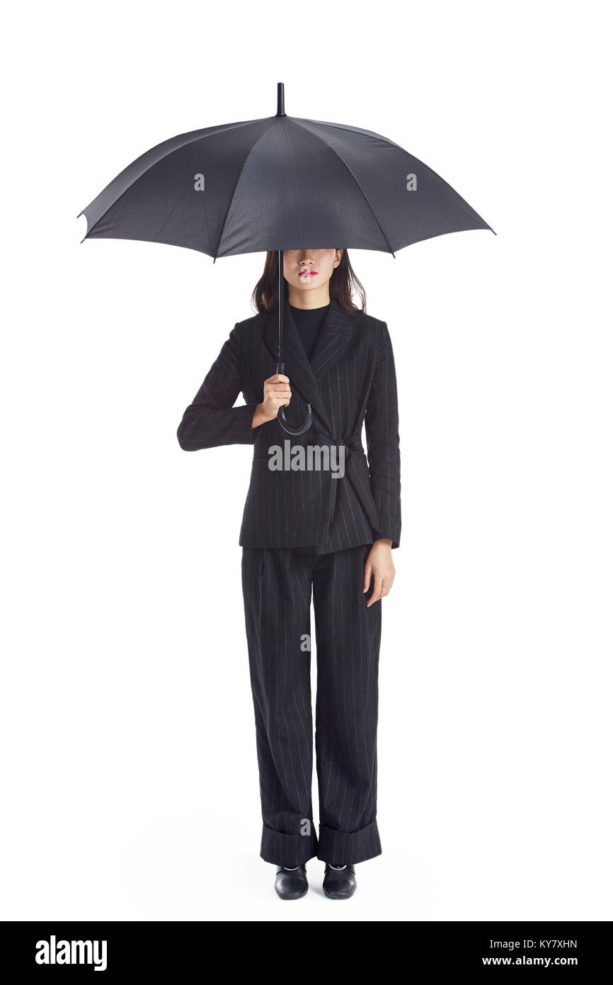 Studio shot of a young asian business woman holding un parapluie noir, isolé sur fond blanc. Banque D'Images