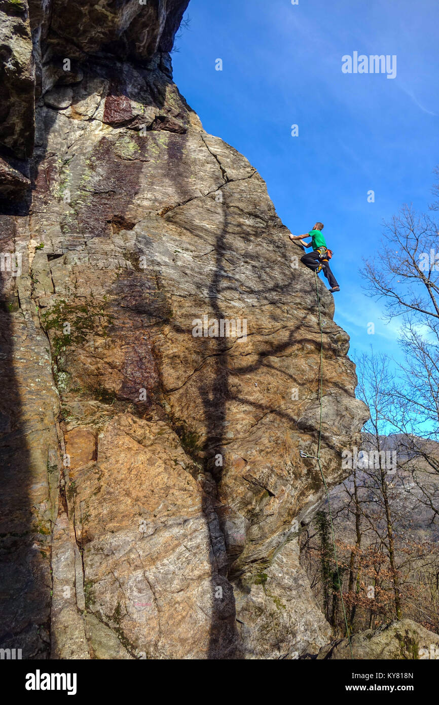Male rock climber sur falaise de granit raide avec red rock et ciel bleu Banque D'Images