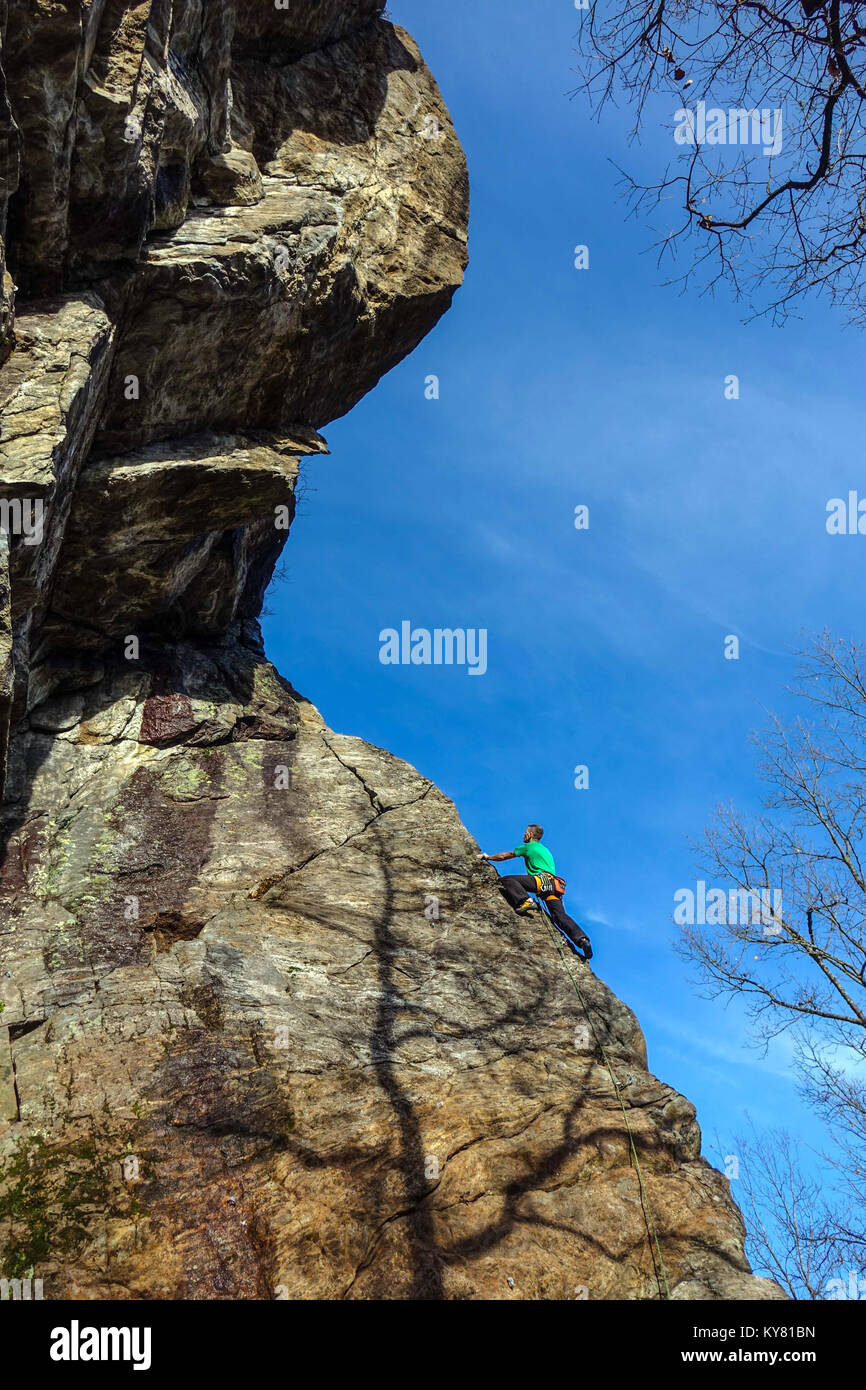 Male rock climber sur falaise de granit raide avec red rock et ciel bleu Banque D'Images