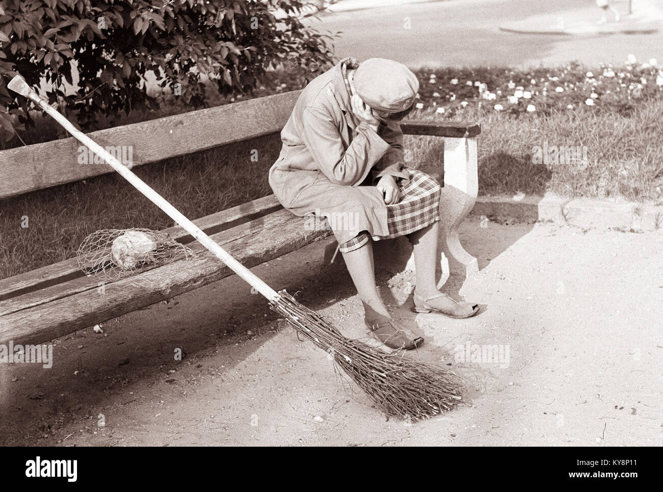 Cette photographie de 1961 intitulée 'Počitek ob sončnem vzhodu' (repos au lever du soleil) représente une figure solitaire se reposant à l'extérieur à l'aube. L'image capture le moment tranquille et la lumière naturelle. Banque D'Images