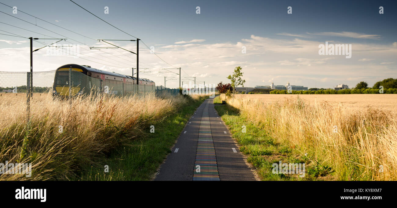 Cambridge, Angleterre, Royaume-Uni - dans les terres agricoles au sud de Cambridge, une plus grande Anglia 170 diesel classe régionale train de voyageurs passe le 'DNA way' cycle path, p Banque D'Images