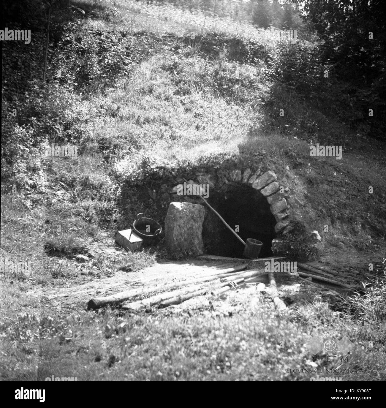Cette photographie représente le printemps 'Supat' situé à la périphérie du village de Vino en 1948, illustrant le paysage rural et la source d'eau locale. Banque D'Images