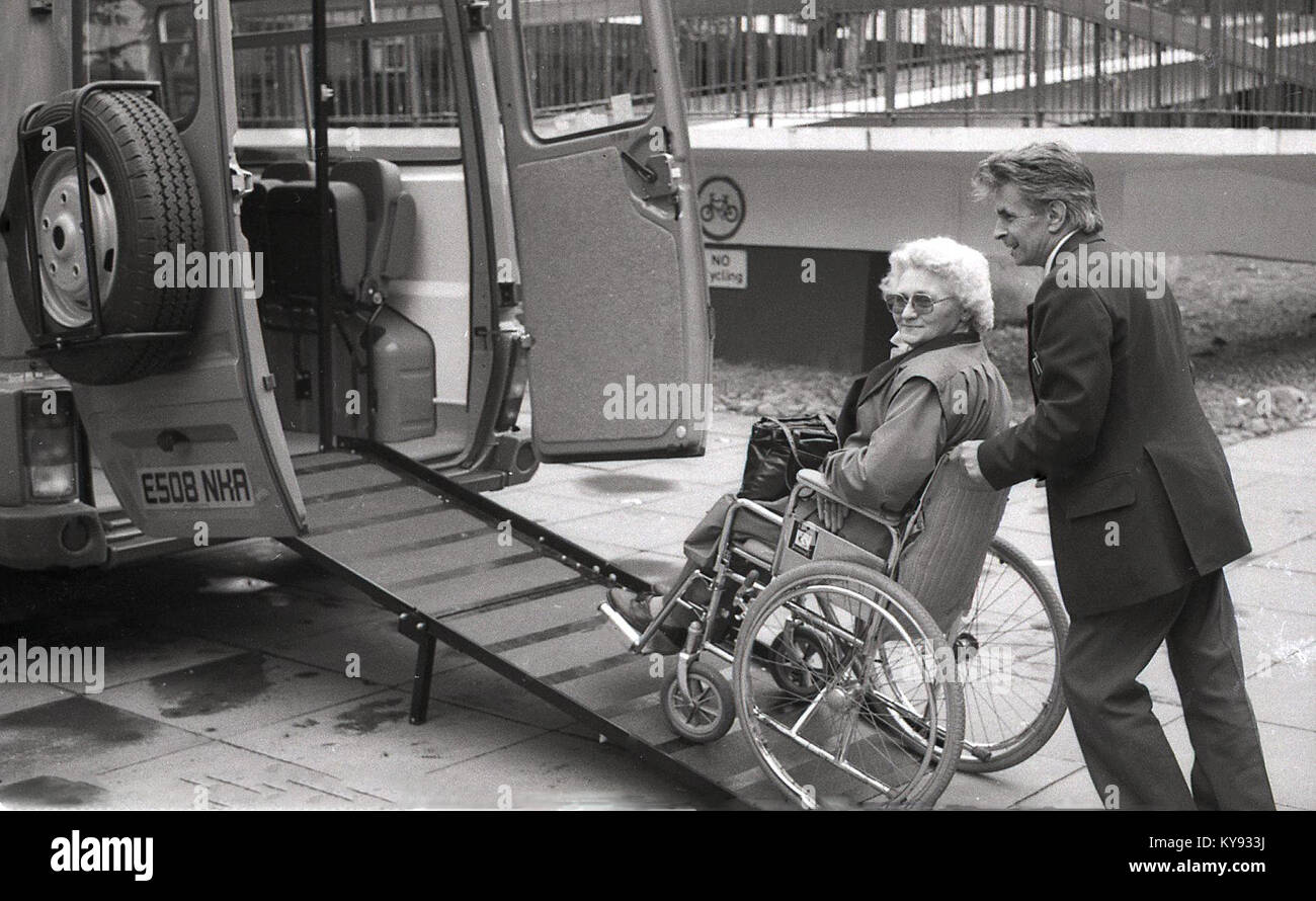 Années 1980, historique, vieille dame en fauteuil roulant est poussé vers le haut une rampe dans une fourgonnette dans le cadre du service de Communicare les personnes handicapées et les personnes âgées offerts par Conseil Easington County Durham, Angleterre. Banque D'Images