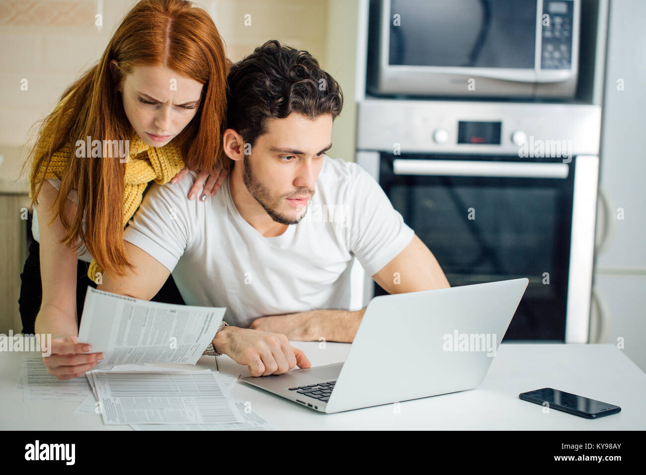 Couple paying bills with laptop Banque D'Images