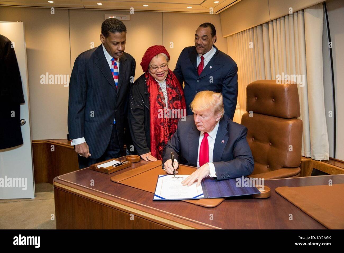 Le Président américain Donald Trump signe le Martin Luther King Jr. National Historical Park Act au cours d'une cérémonie à bord d'Air Force One le 8 janvier 2018 à Atlanta, Géorgie. À la recherche sur sont Isaac Newton Farris Jr., gauche, neveu du Dr King, Alveda King, Centre, nièce du leader des droits civils tués et Bruce Levell de la diversité nationale, Coalition pour Trump, droite. Banque D'Images