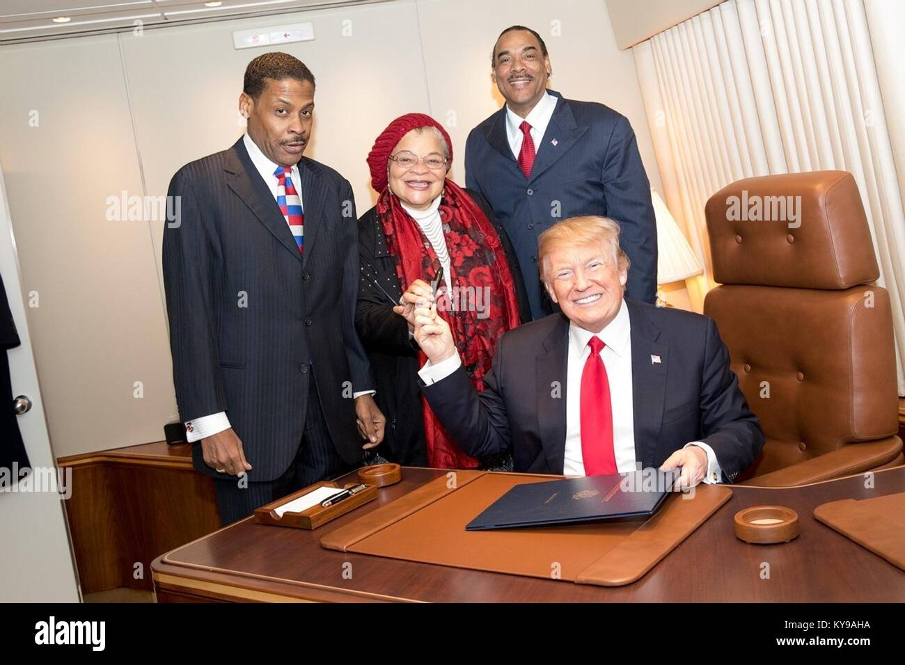 Le Président américain Donald Trump mains le stylo utilisé pour signer le Martin Luther King Jr. National Historical Park Act à Alveda King, Centre, nièce du leader des droits civils tués à bord d'Air Force One le 8 janvier 2018 à Atlanta, Géorgie. À la recherche sur sont Isaac Newton Farris Jr., gauche, neveu du Dr King, et Bruce Levell de la diversité nationale, Coalition pour Trump, droite. Banque D'Images