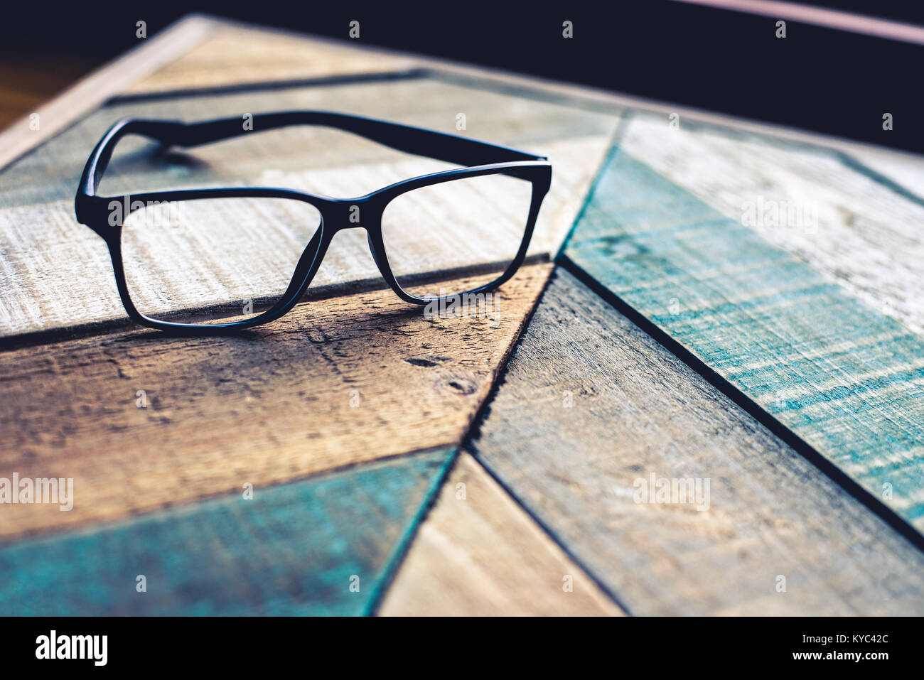 Cadre noir moderne lunettes sur weathered wood surface avec motif angulaire. Banque D'Images