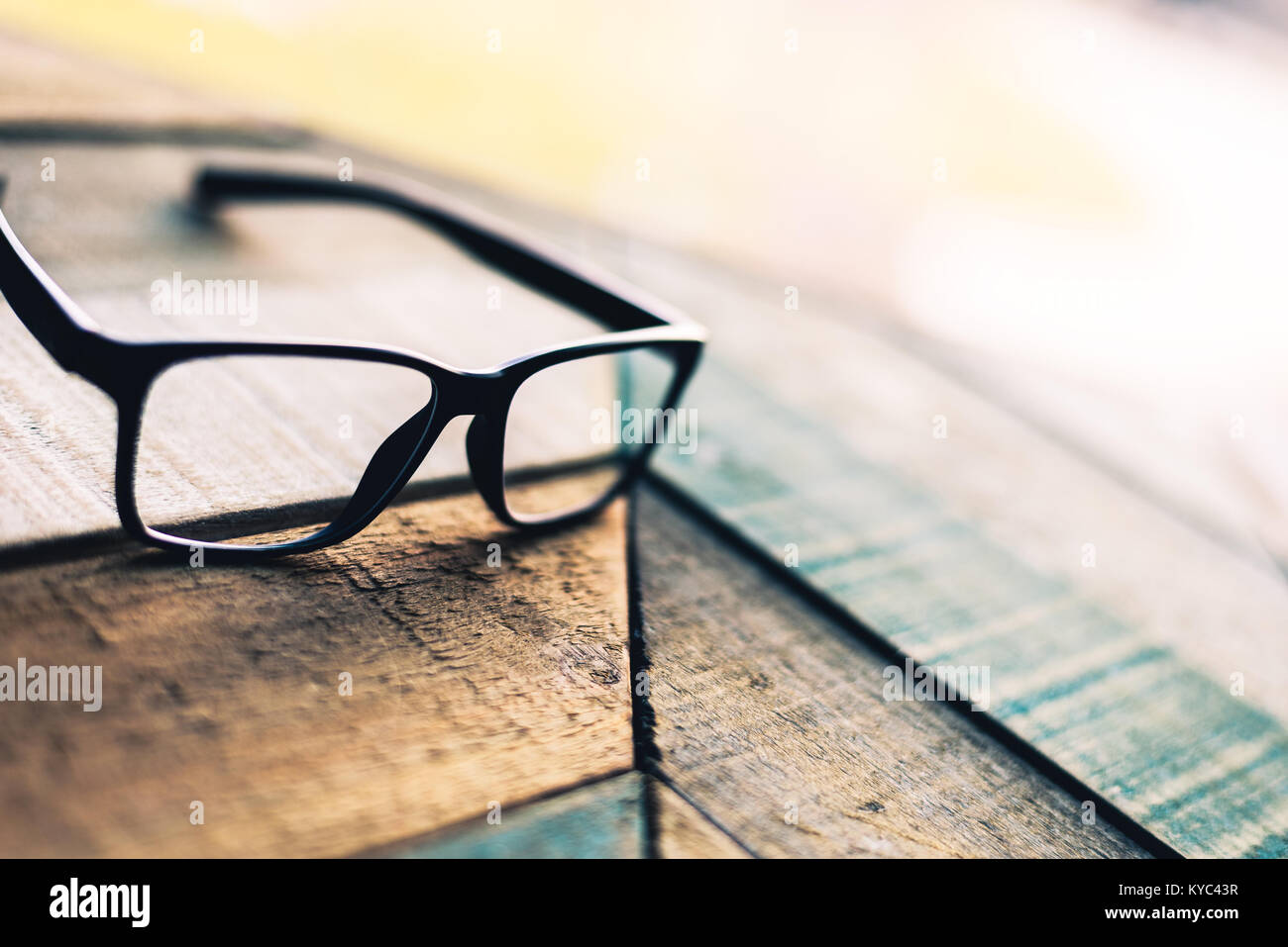 Cadre noir moderne lunettes sur weathered wood surface avec motif angulaire. Banque D'Images