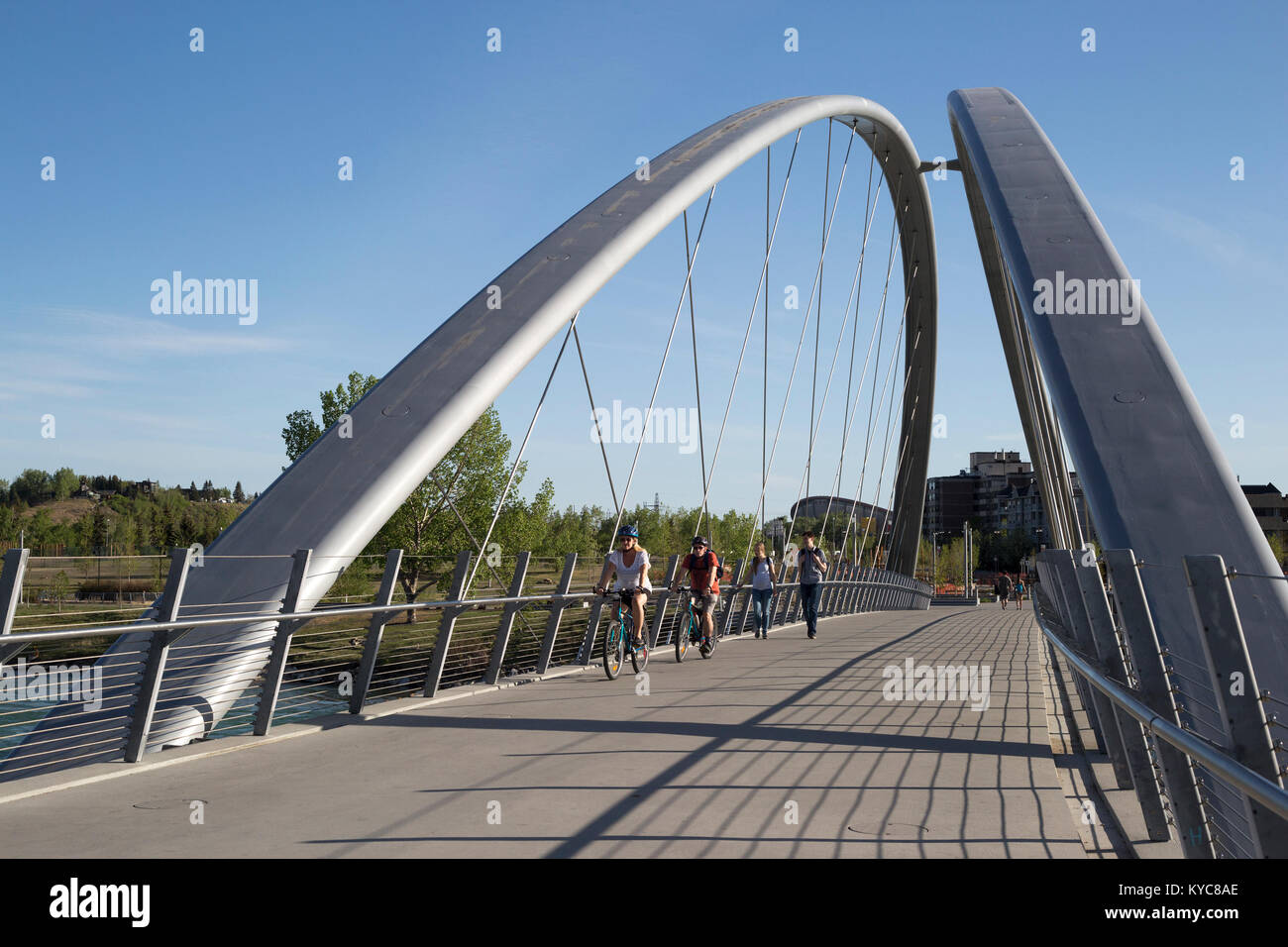 Cyclistes et piétons traversant le pont George C. King au-dessus de la rivière Bow entre East Village et St. Patrick's Island et Bridgeland Banque D'Images