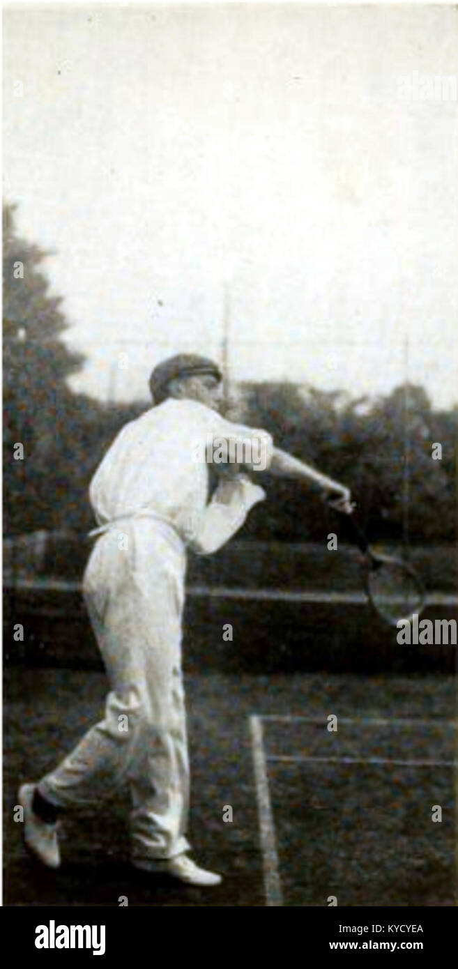 Une photographie à mi-action du joueur de tennis belge Paul de Borman exécutant un service, capturant la deuxième étape de son mouvement. L'image met en valeur sa forme athlétique et sa technique de tennis du début du XXe siècle. Banque D'Images