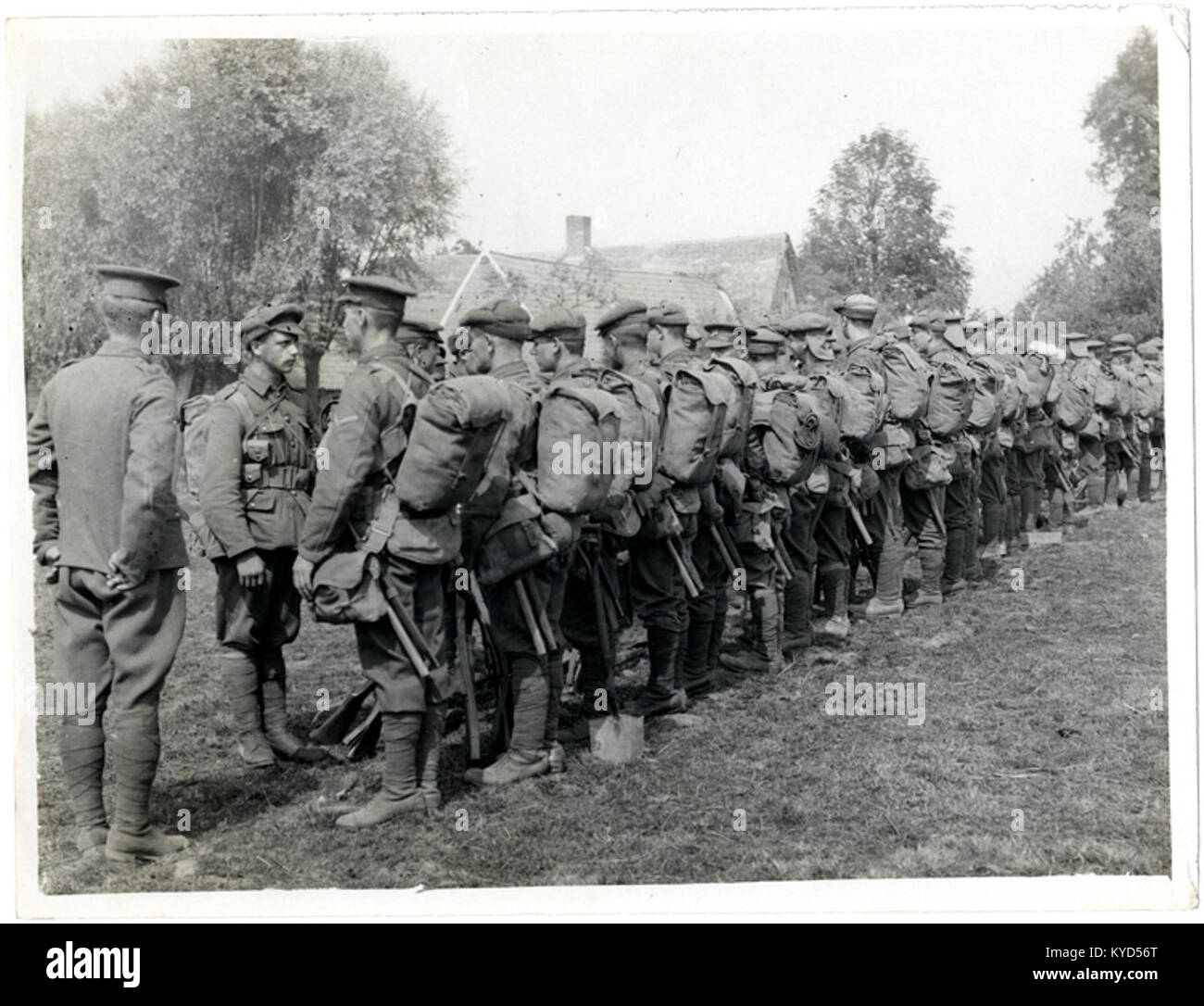 Une photographie historique montrant un peloton militaire défilant en formation à l'extérieur de leur caserne. L'image illustre la discipline militaire, l'uniformité et la vie militaire au début du XXe siècle. Banque D'Images