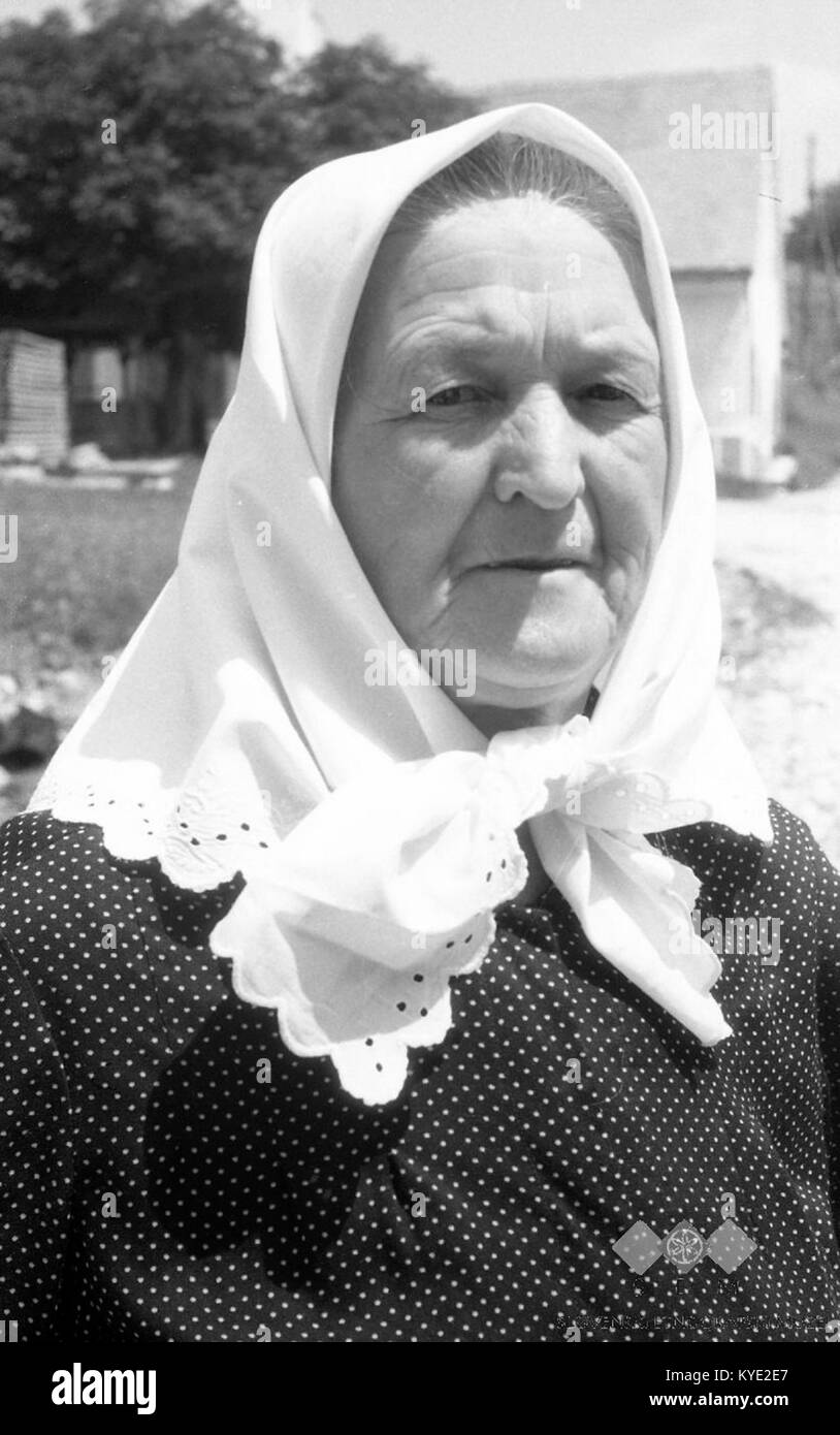 Cette photographie montre Lucija Oprešnik, une femme de 60 ans originaire de Brezen, portant un foulard traditionnel. L'image capture un aspect de la vie rurale slovène et de l'habillement culturel dans les années 1960 Banque D'Images