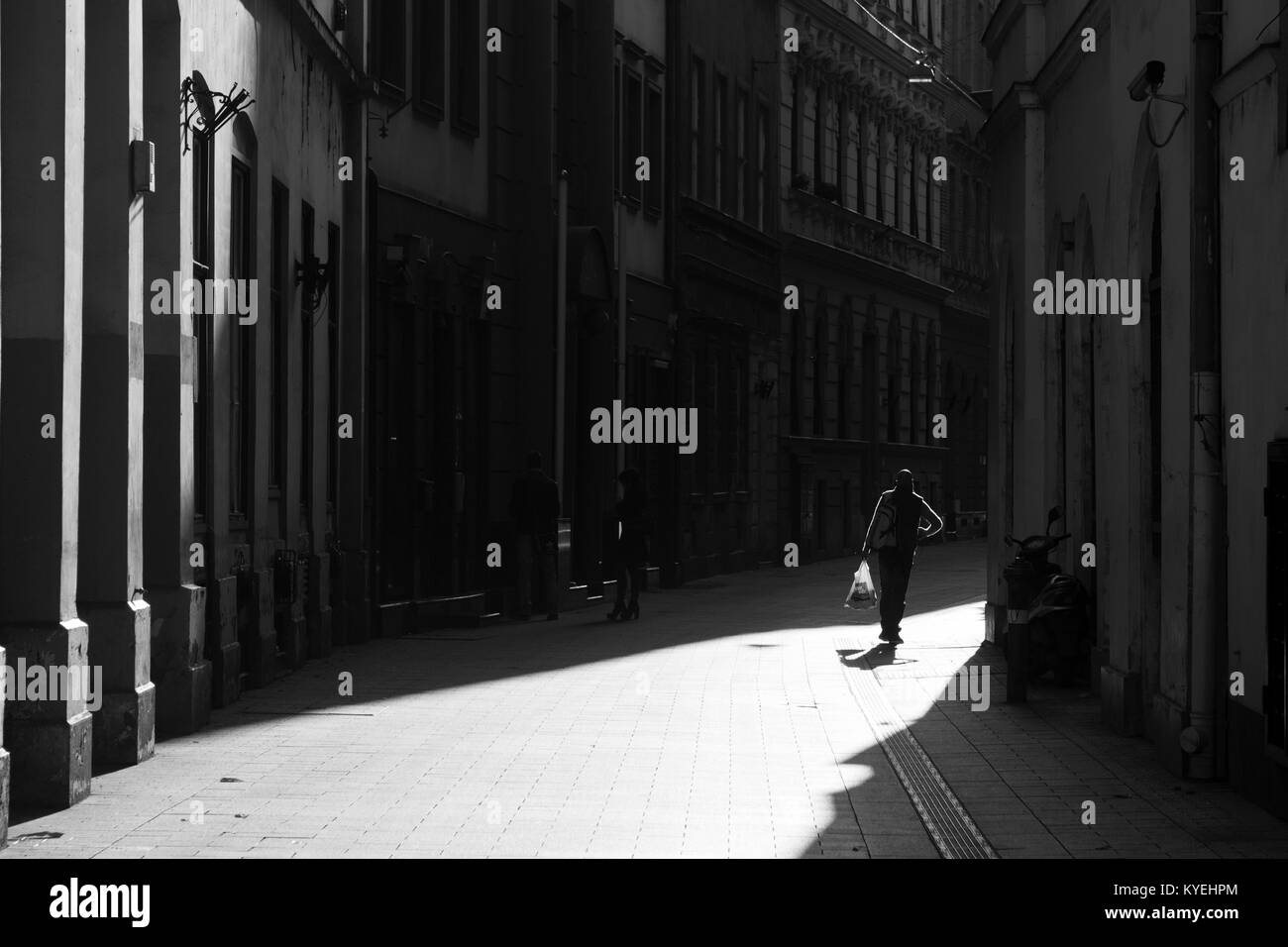 Homme portant un sac en plastique sur la rue sombre silhouette Banque D'Images